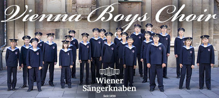 Vienna Boys Choir members in uniform standing outside a historic building with the Wiener Sängerknaben logo.